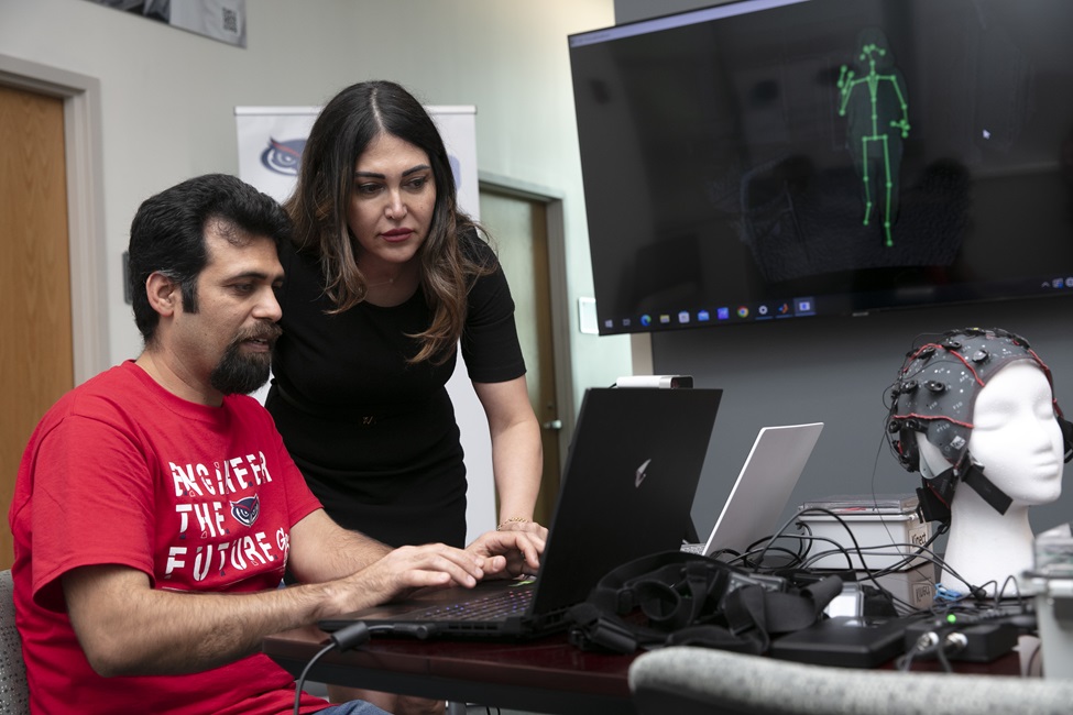 Mahmoud Seifallahi (seated) and Behnaz Ghoraani, Ph.D., review the performance of straight walking using a depth camera, which can detect and track 25 joints of body movement.